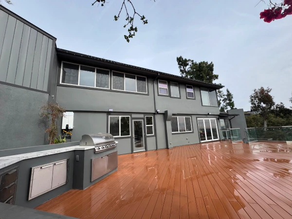 Coastal home with a freshly painted deck and gray siding near the water