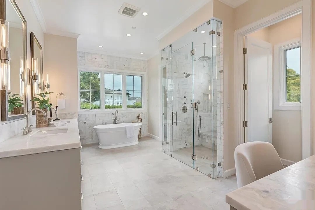 Primary bathroom with soft beige painted walls and marble tile