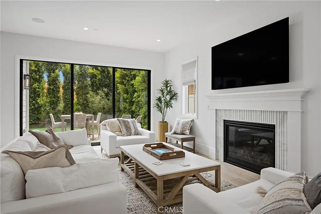 Family room painted bright white with a fireplace and glass slider