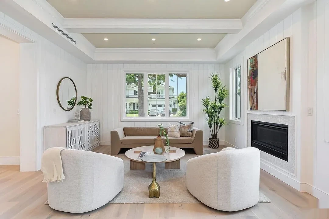 Painted sitting room with white paneled walls and a tray ceiling