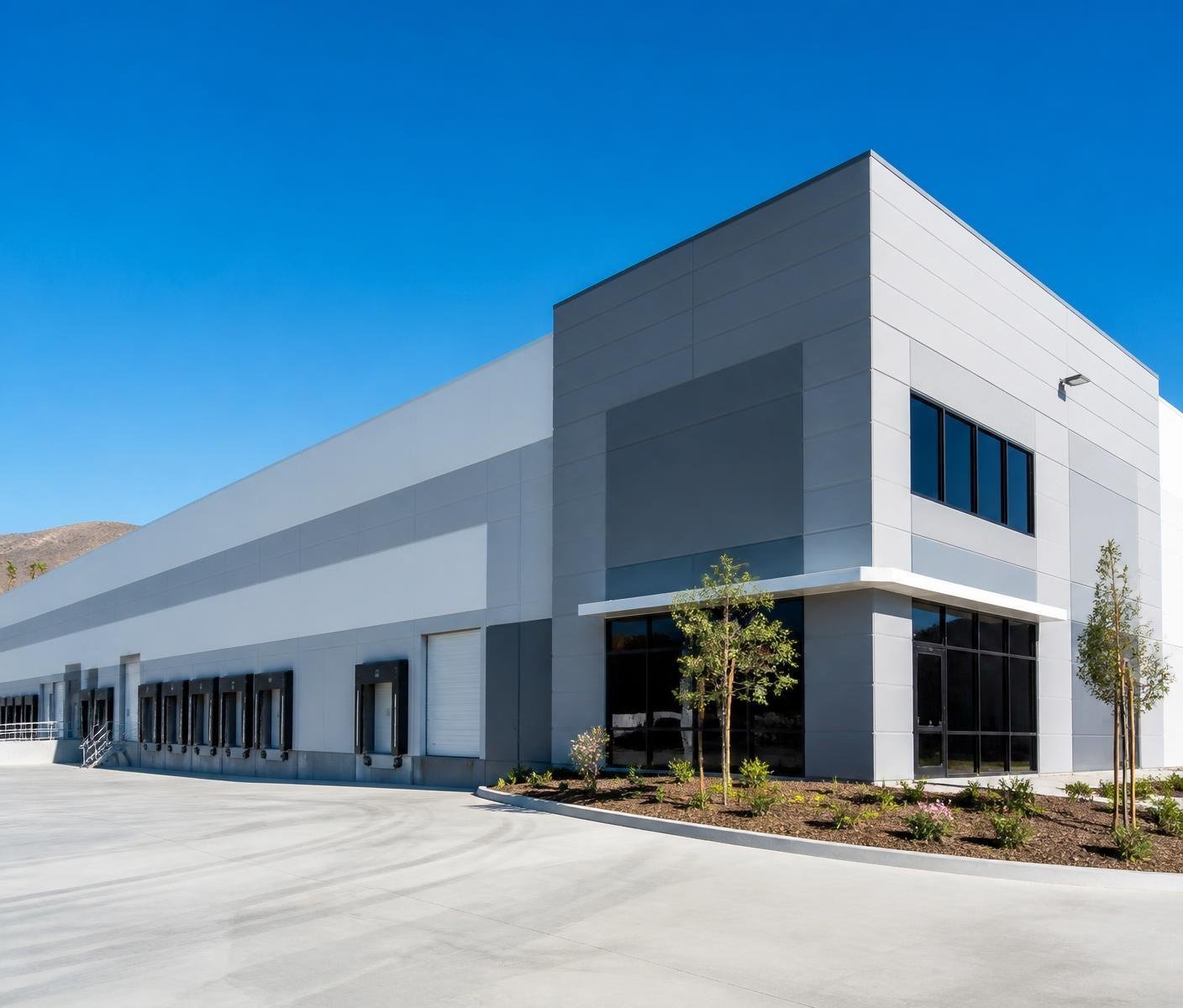 Warehouse exterior painted in two tone gray and white with loading docks