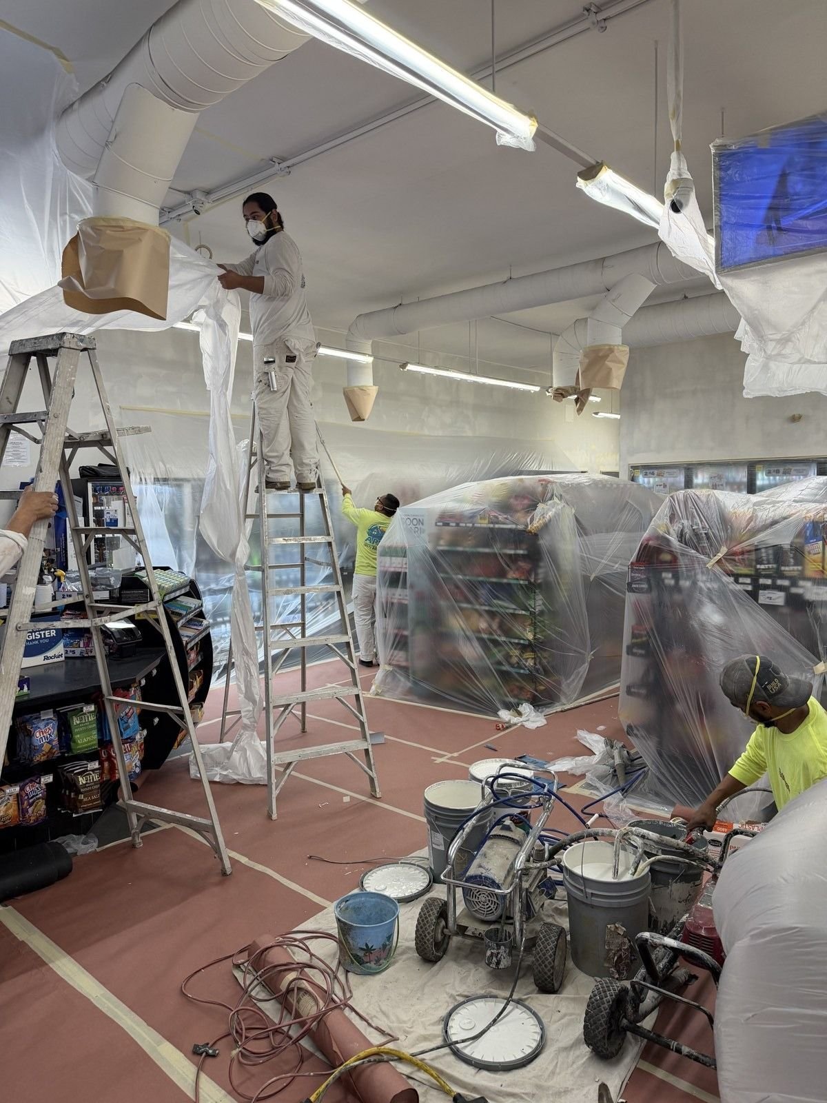 Retail interior masked off with plastic sheeting and floor protection before painting