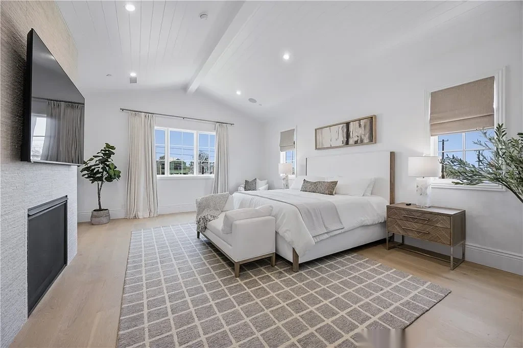 Vaulted bedroom ceiling painted white with a painted beam