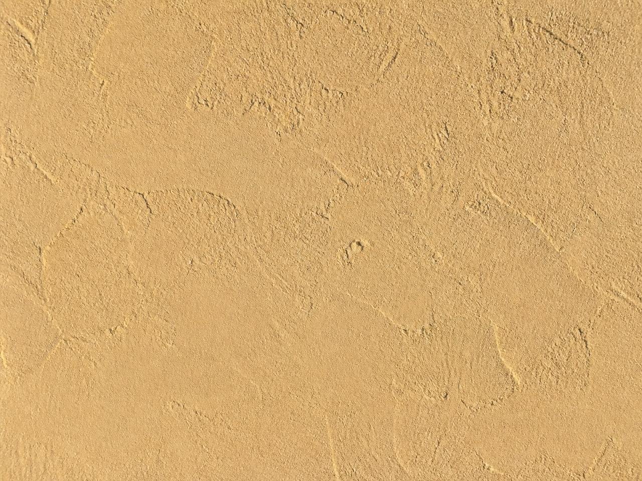 Detail of a hand troweled stucco finish in a warm sand color