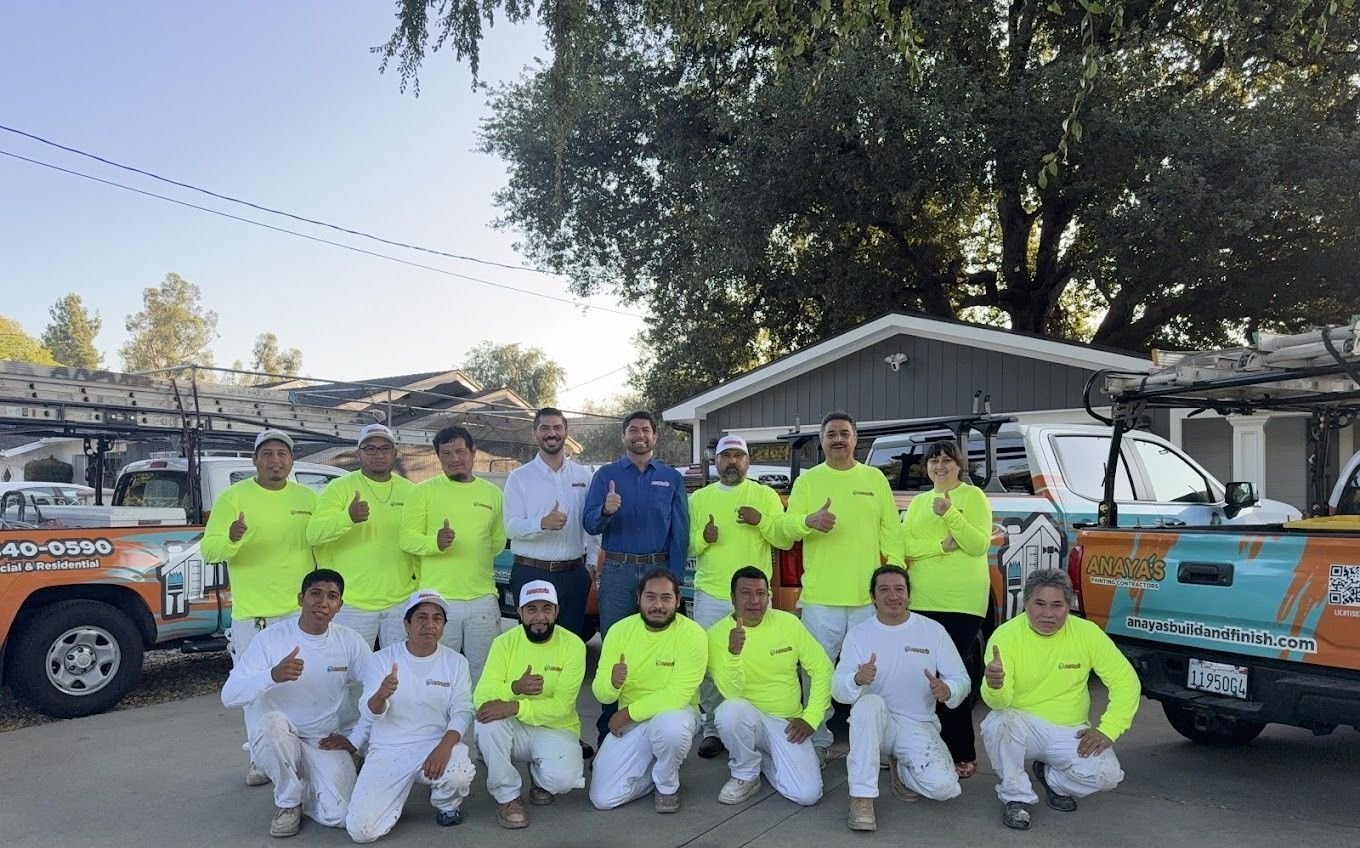 Anaya's Painting crew standing together in front of a finished home